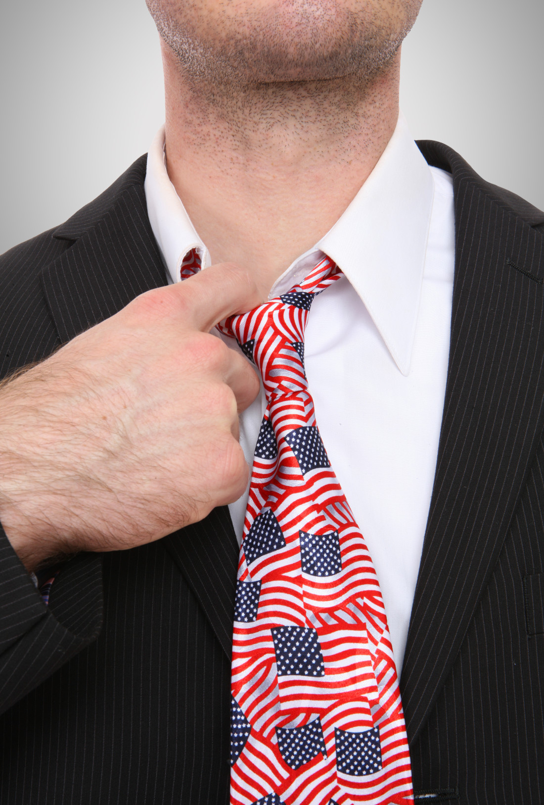 Image of person in suit wearing a neck tie with American Flag print