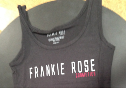 Black sleeveless shirt displaying FRANKIE ROSE on white letters inside the back neck and on the front with COSMETICS in red letters on the front below ROSE. 