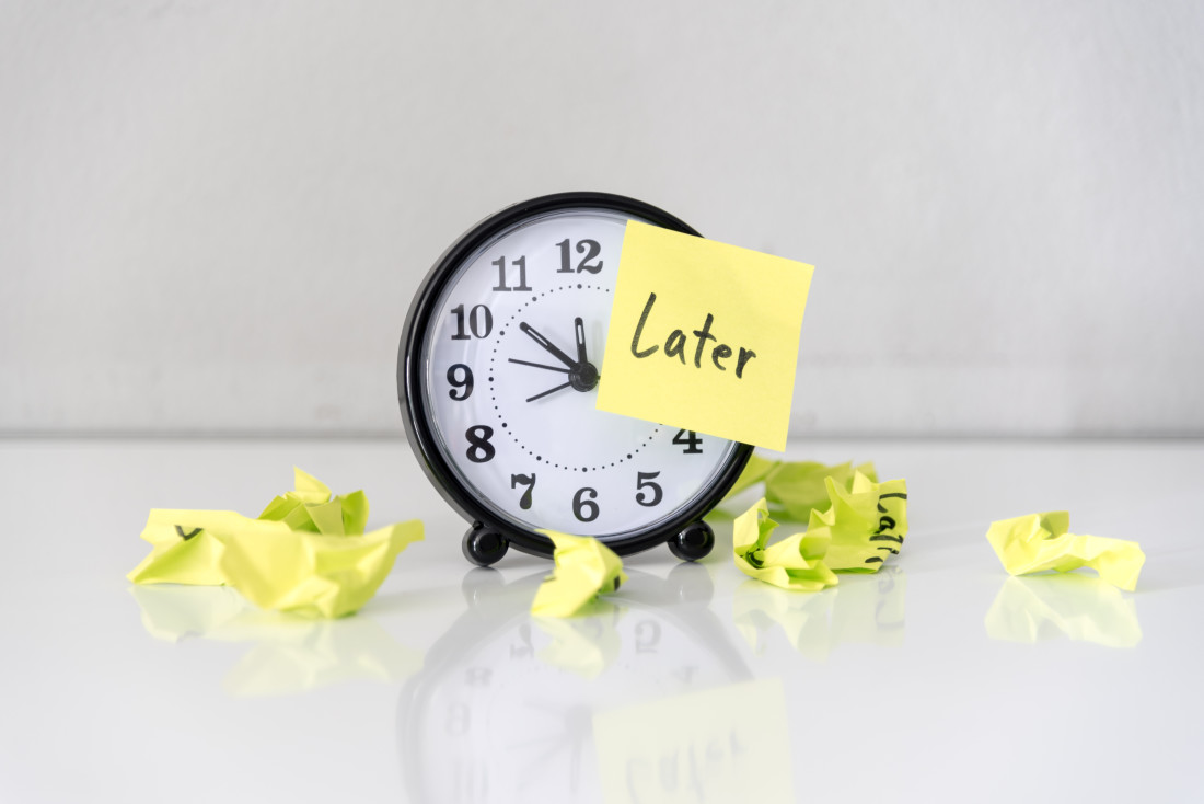 Alarm Clock with sticky note saying “Later” on its face