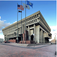 Boston City Hall Plaza with three adjacent flagpoles flying flags.