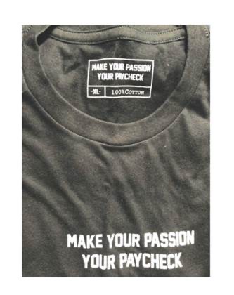 T-Shirt displaying MAKE YOUR PASSION YOUR PAYCHECK on a neck label above XL and 100% Cotton, and also on the front of the T-Shirt.