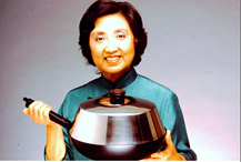 Photo of Joyce Chen holding a flat bottomed wok with a handle.