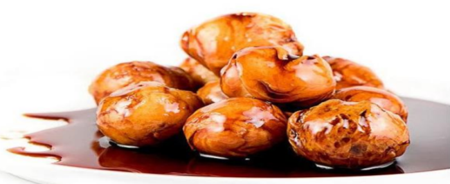 Picture of Greek fried dough balls, soaked in honey syrup and topped with cinnamon or walnuts, known as “loukoumádes.”