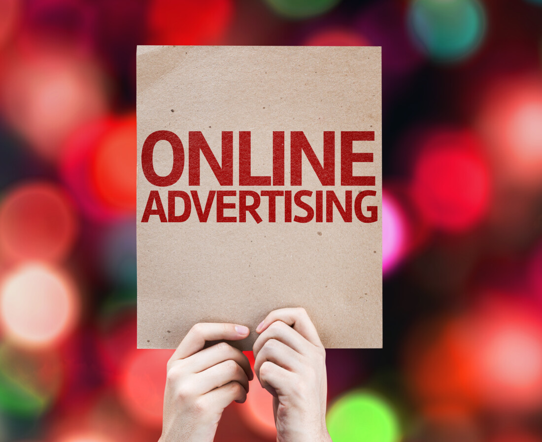 Hands holding up a sign saying ONLINE ADVERTISING